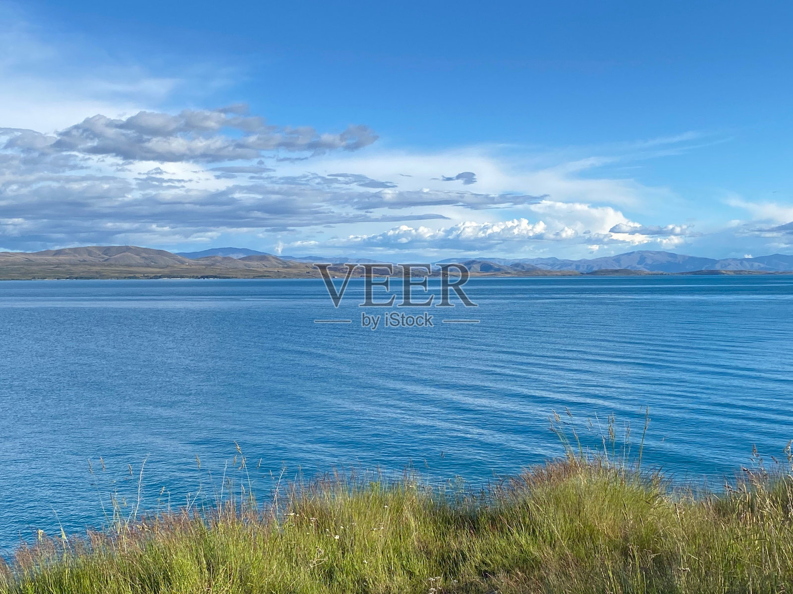 蓝天白云下的蓝色湖泊的美丽景色。照片摄影图片