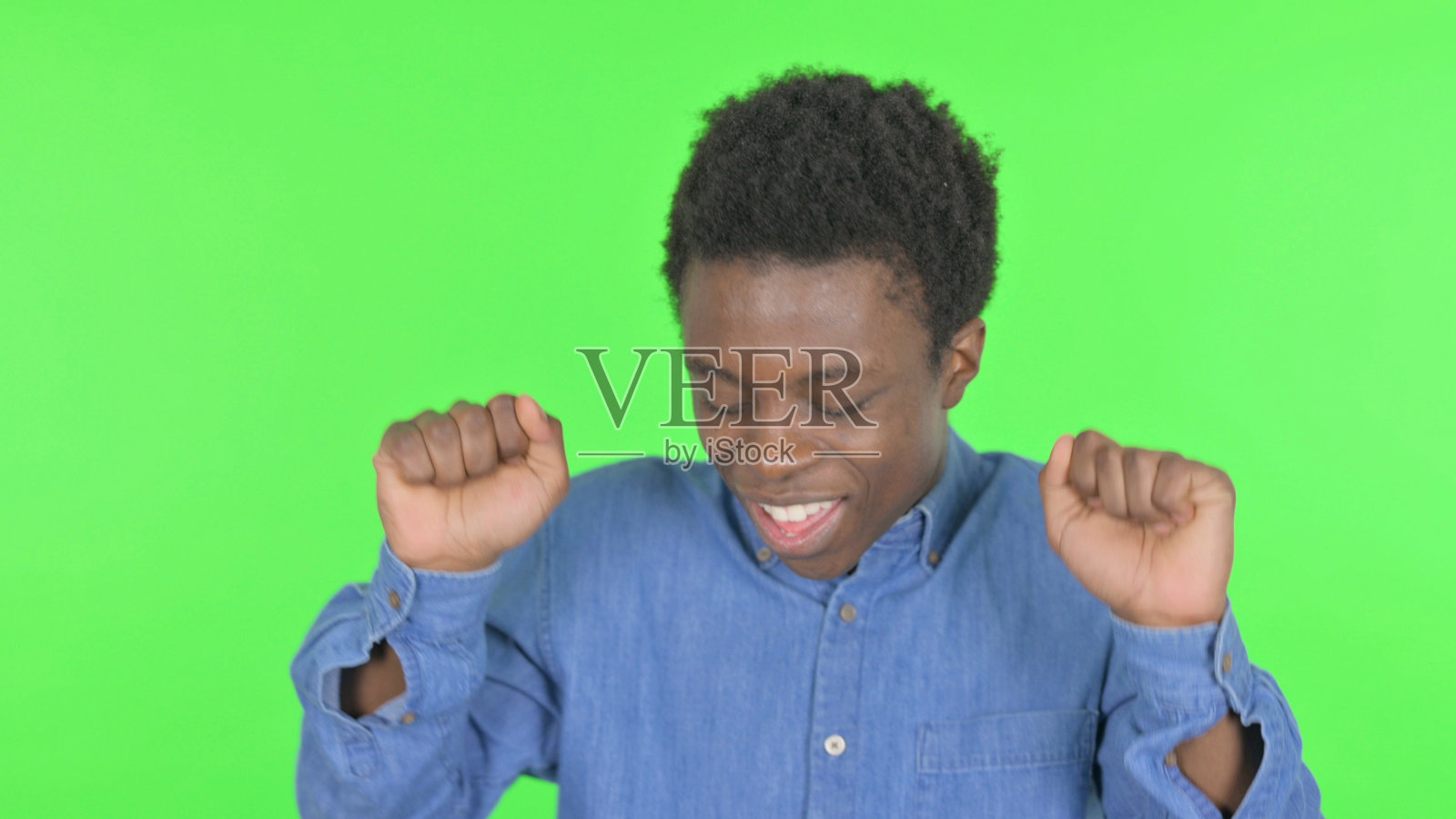 年轻的非洲人在绿色背景下快乐地跳舞照片摄影图片