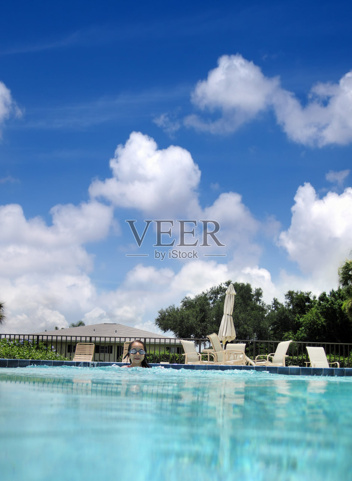 小女孩跳进佛罗里达的游泳池照片摄影图片