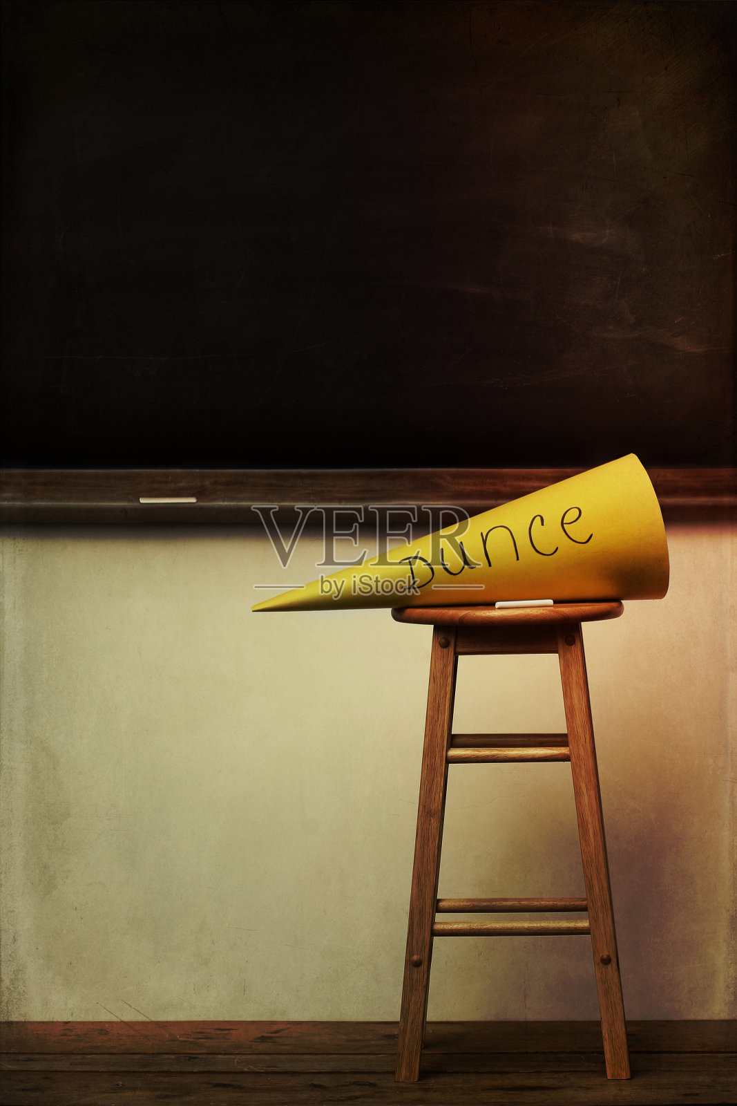 黄色的笨蛋帽子在凳子上和黑板照片摄影图片