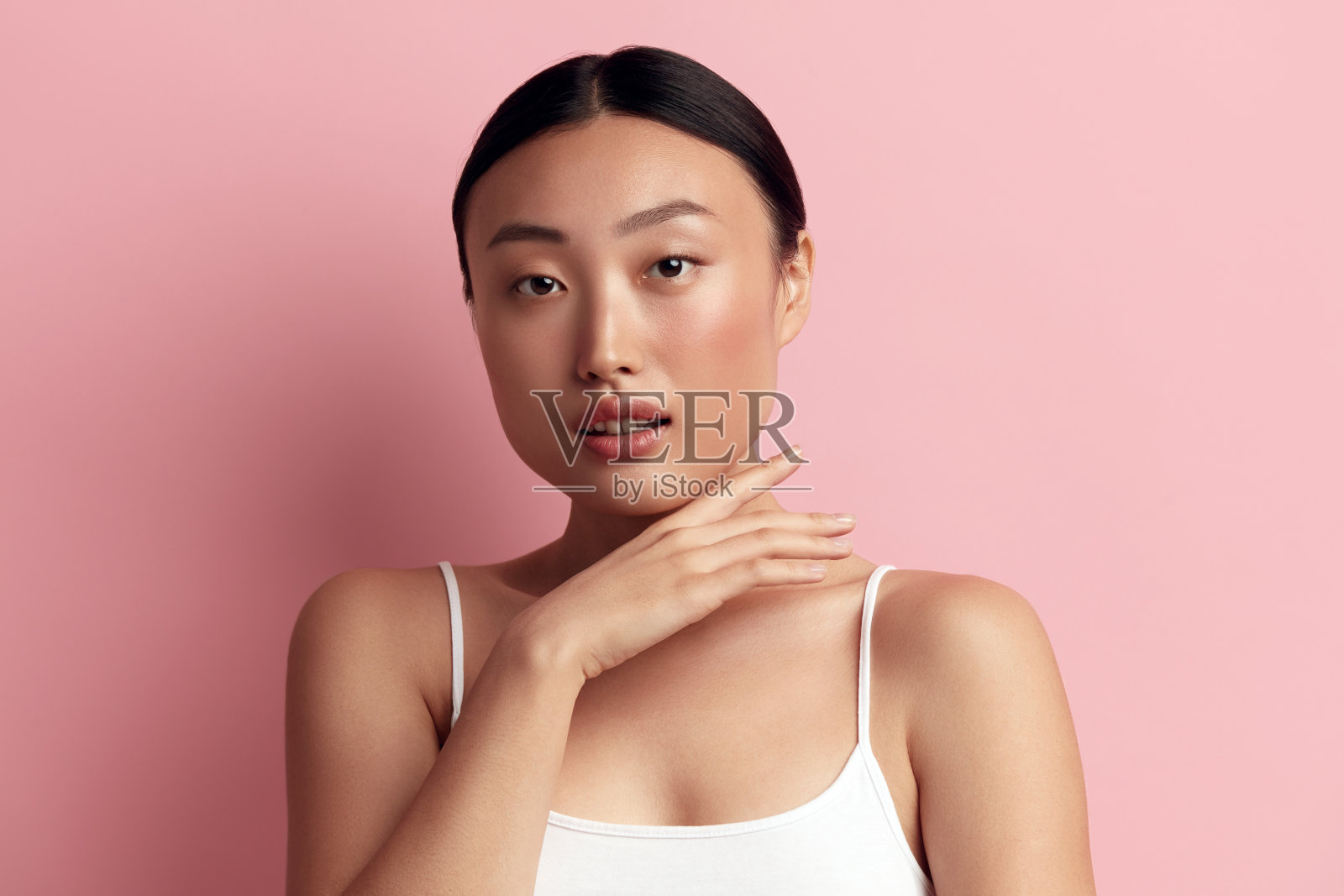 温柔的女人感动小鸡。正面的亚洲女性触摸她的脸的肖像照片摄影图片