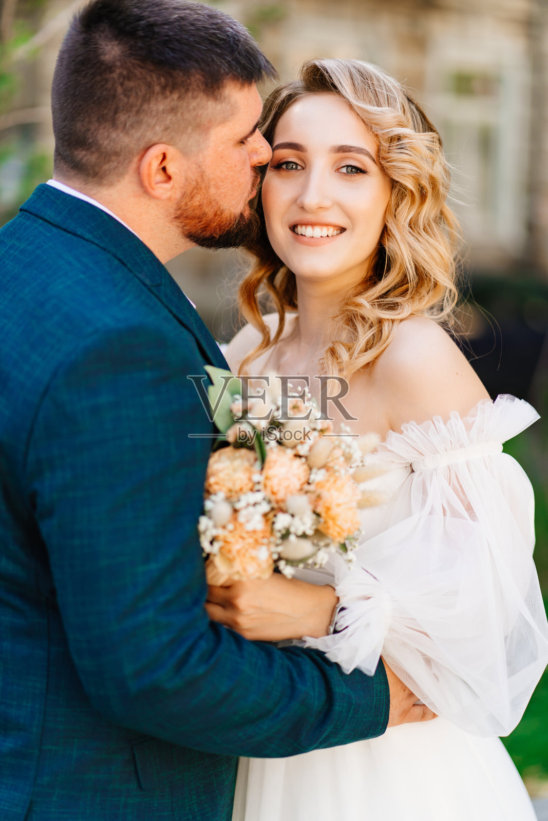 新郎温柔地拥抱并亲吻新娘。照片摄影图片