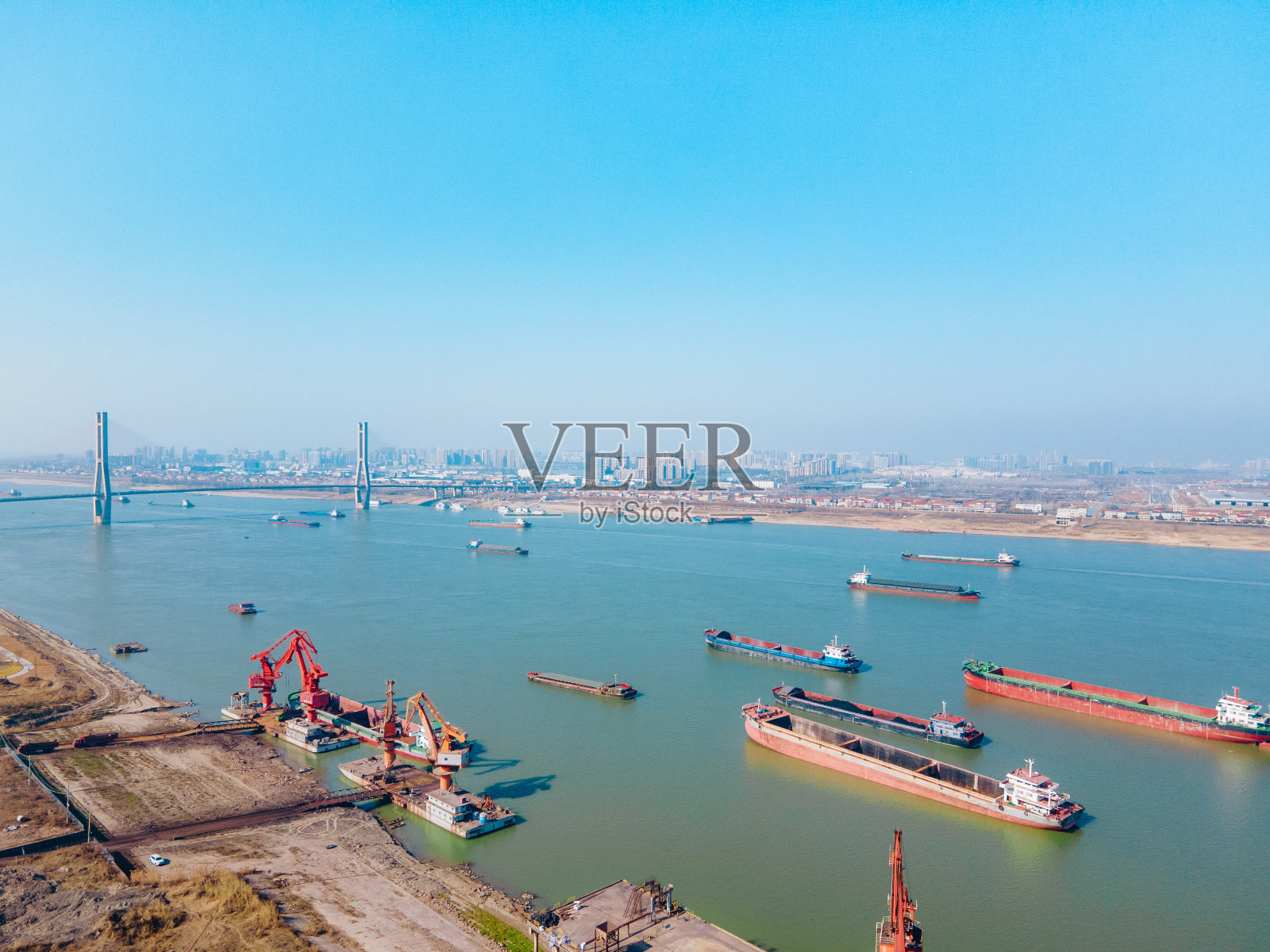 码头起重机和运输货物的船只照片摄影图片