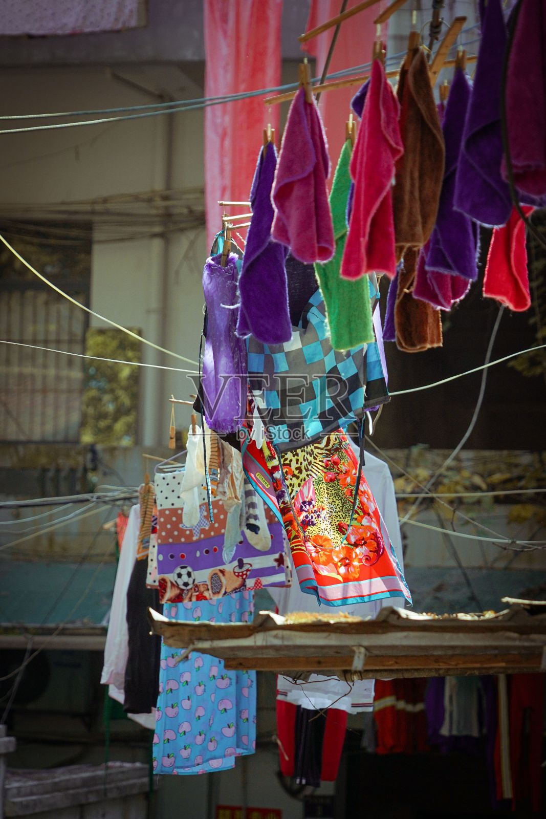 垂直特写镜头，在阳光明媚的日子里，在建筑物之间的街道上洗衣照片摄影图片