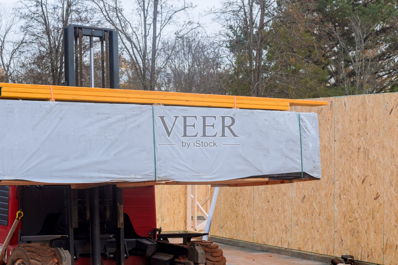 在叉车的帮助下，建筑材料正在被卸下照片摄影图片