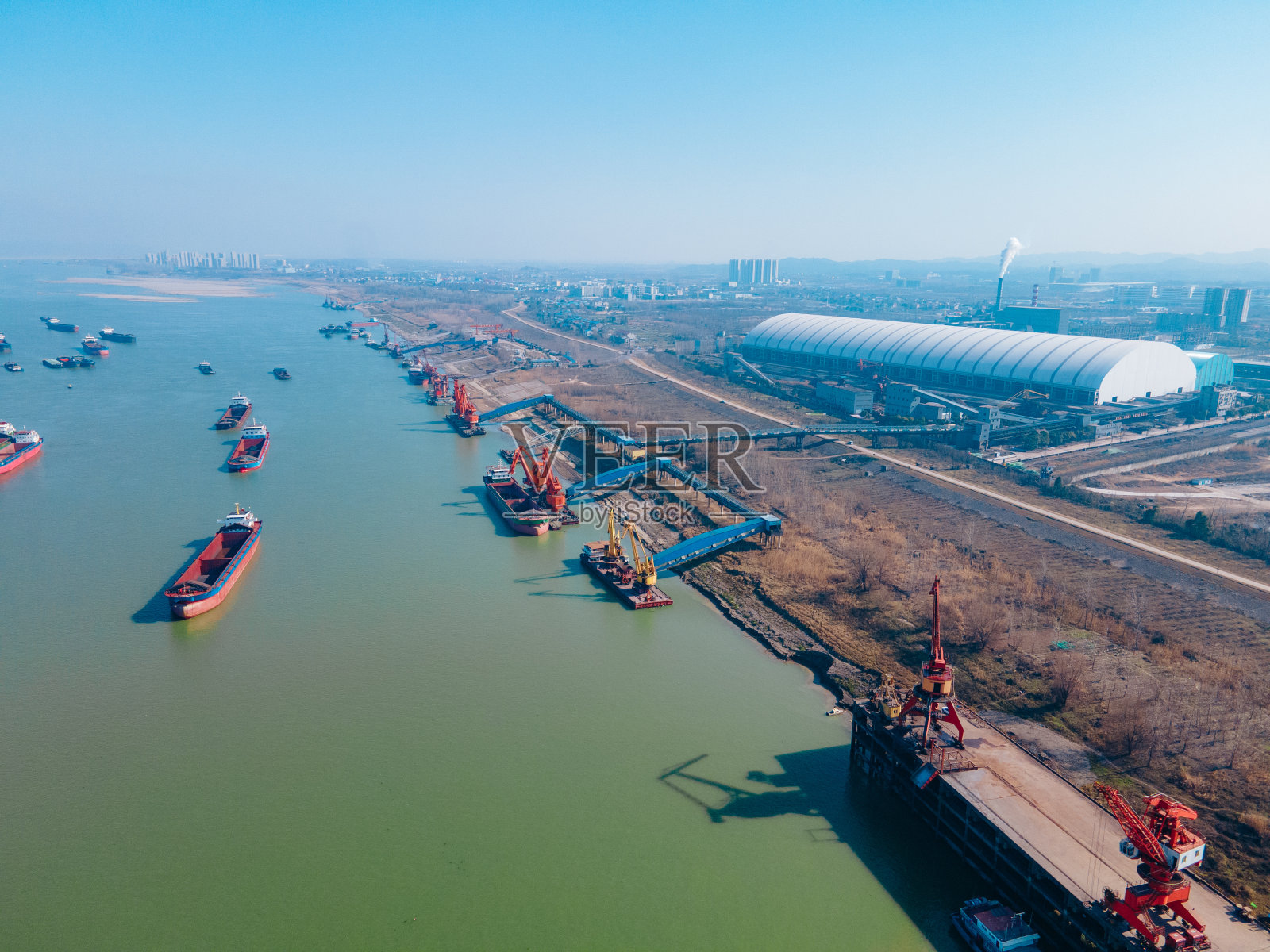 码头起重机和运输货物的船只照片摄影图片