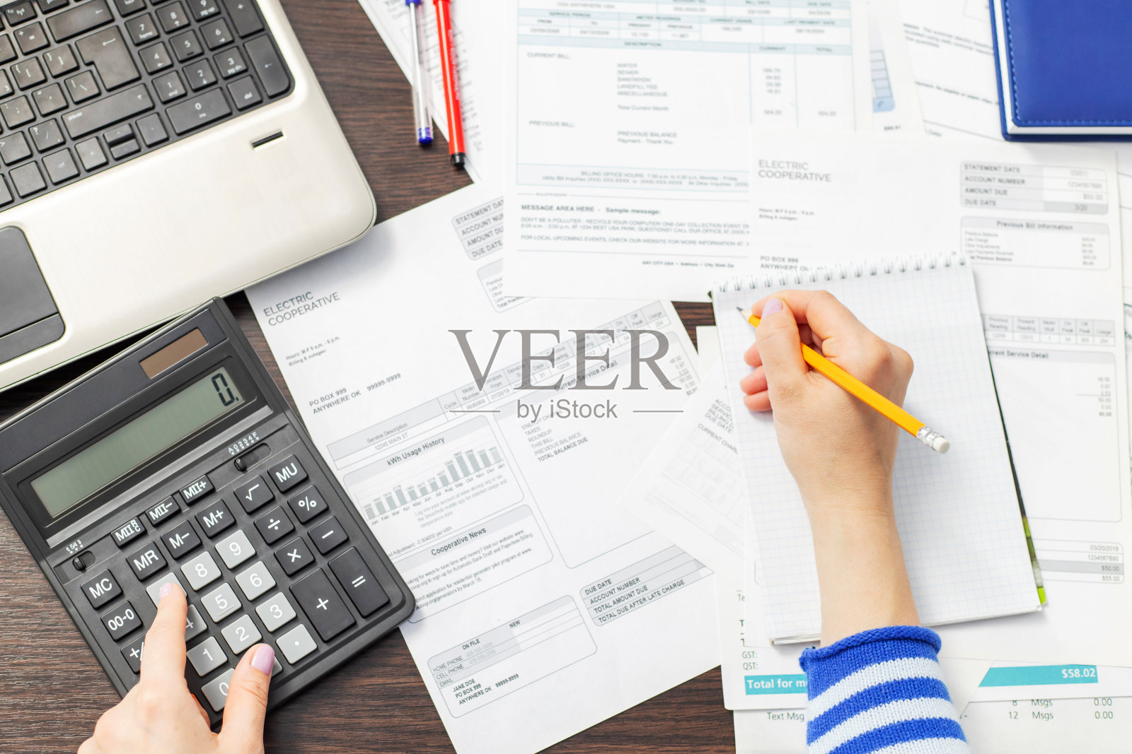 女人在家里用计算器计算家庭账单照片摄影图片