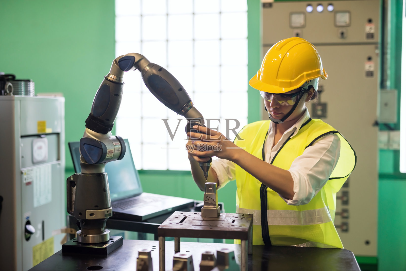 工厂审核员戴着安全帽检查AI车床自动化机械臂照片摄影图片