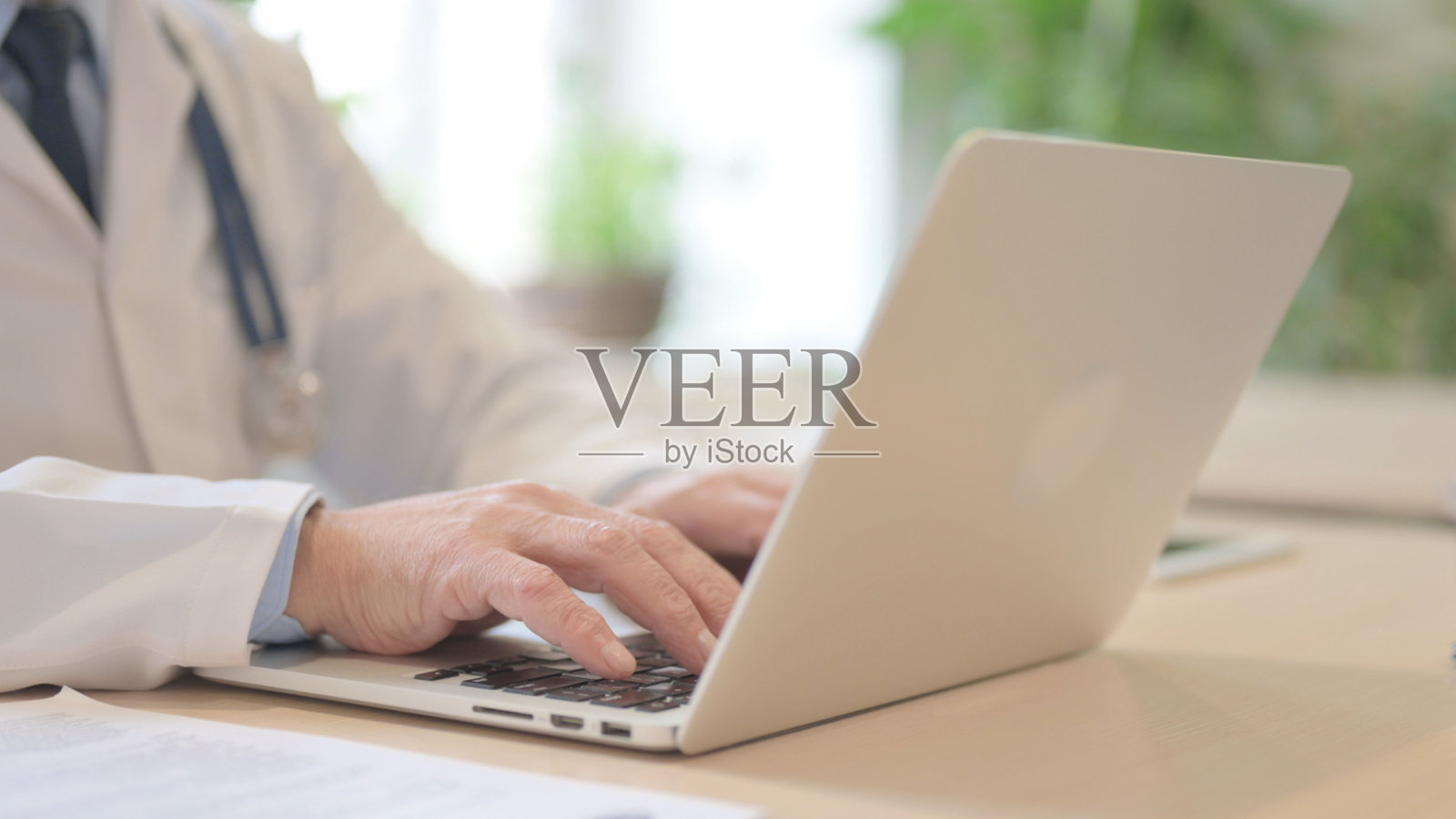 高级医生在笔记本电脑上打字的特写照片摄影图片