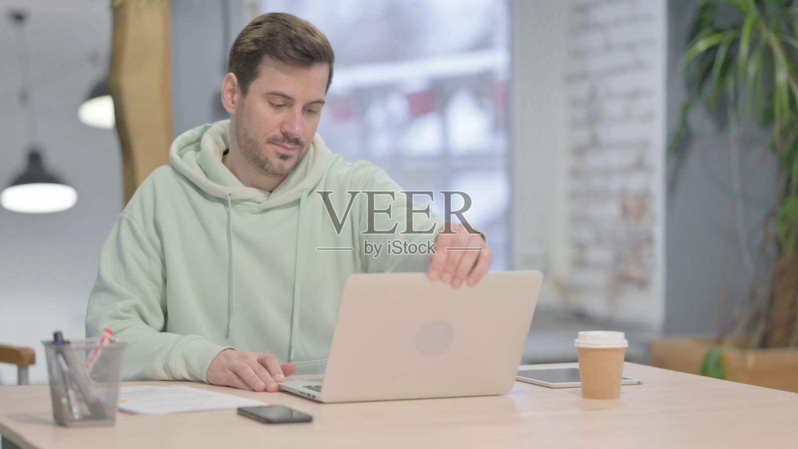 年轻人回到办公室，打开笔记本电脑照片摄影图片