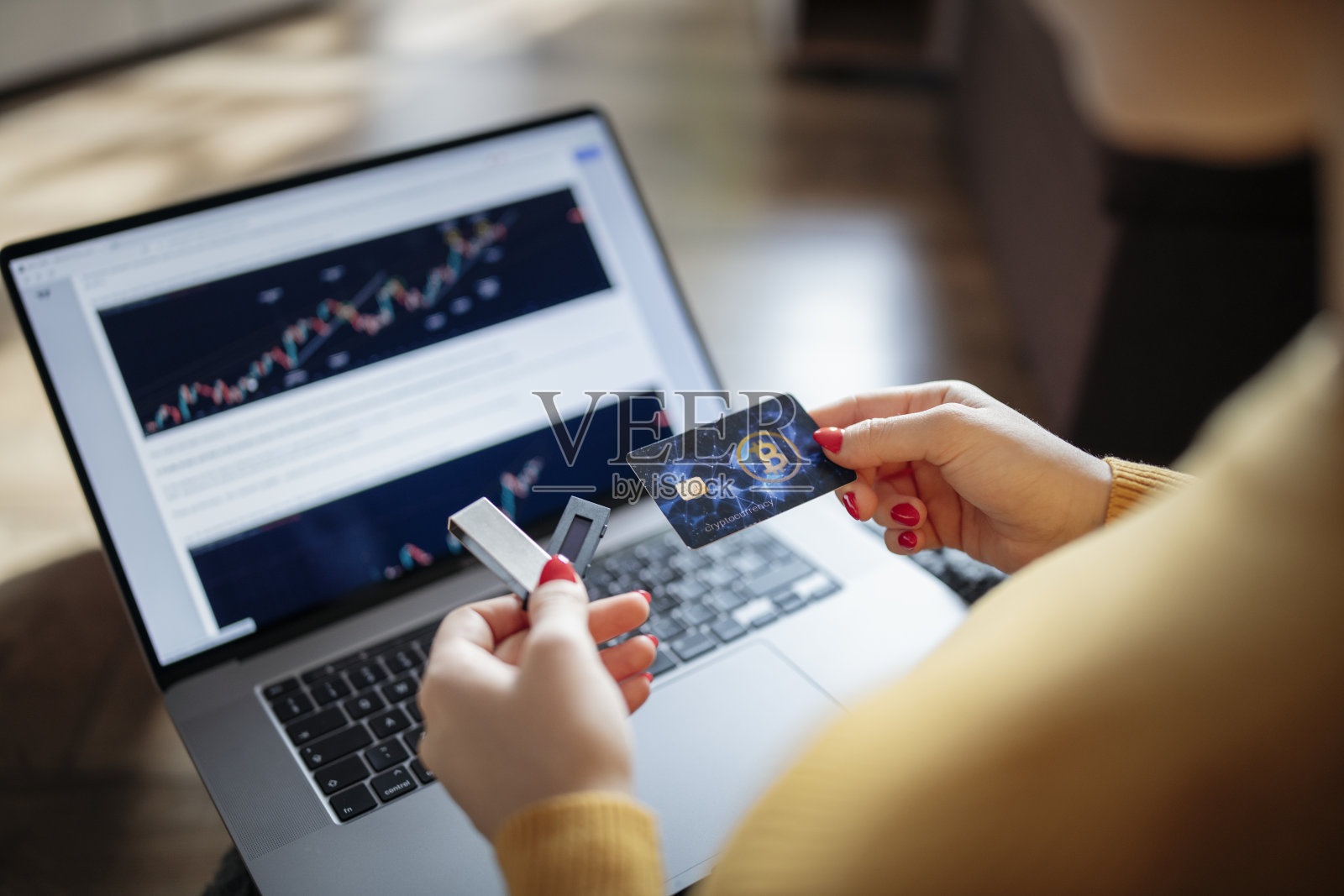 手持数字钱包USB存储和加密货币卡的女子。照片摄影图片