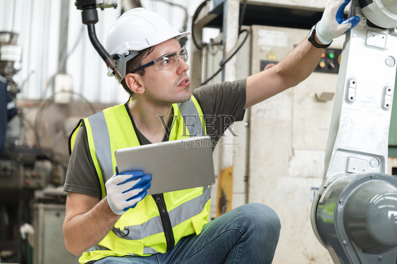 白人技术员工程师在工厂用平板电脑控制检查机械臂机器人照片摄影图片