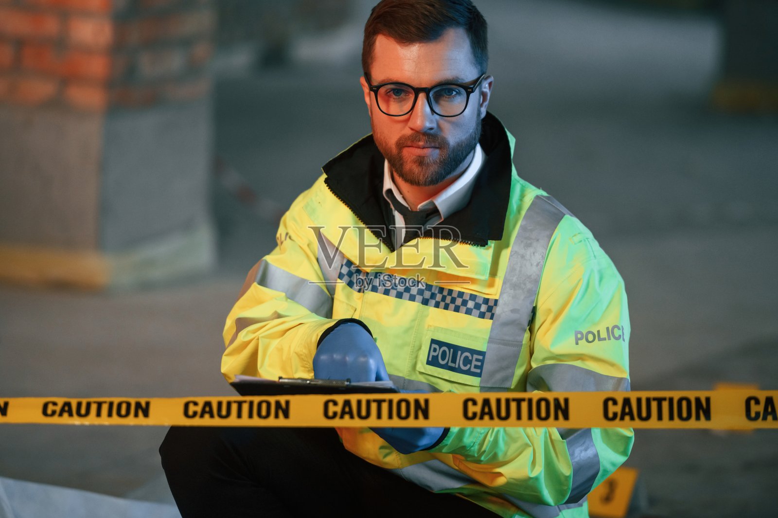 坐着思考。一名男侦探正在建筑工地的犯罪现场收集证据照片摄影图片