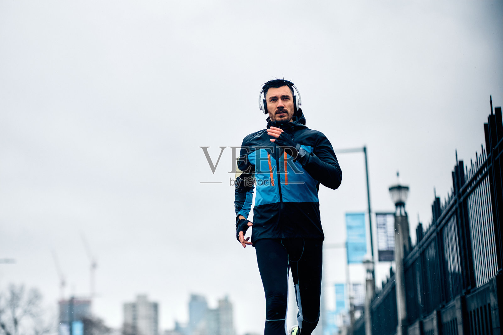 坚定的运动员在雨天户外跑步。照片摄影图片