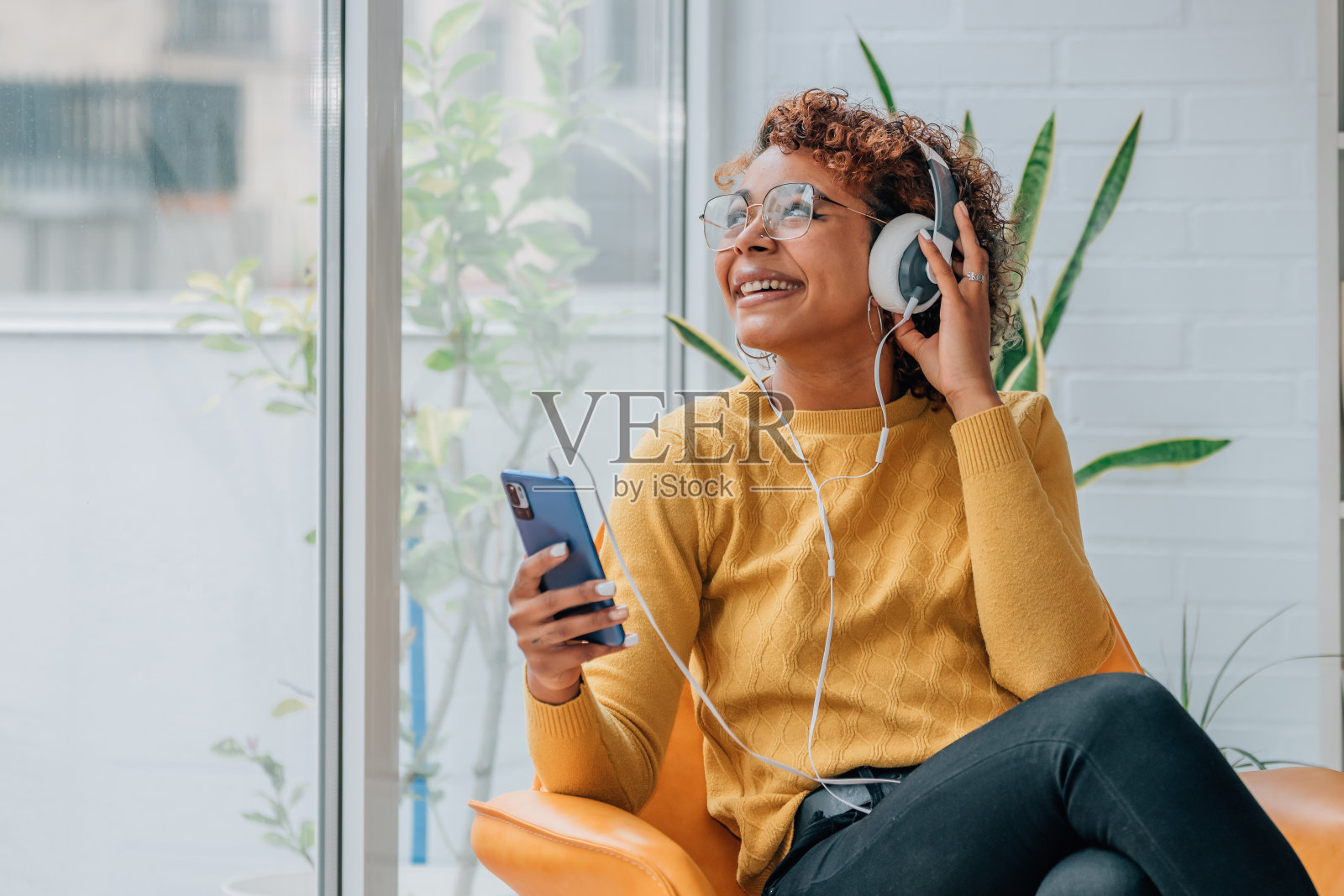 女孩在家里拿着手机和耳机照片摄影图片