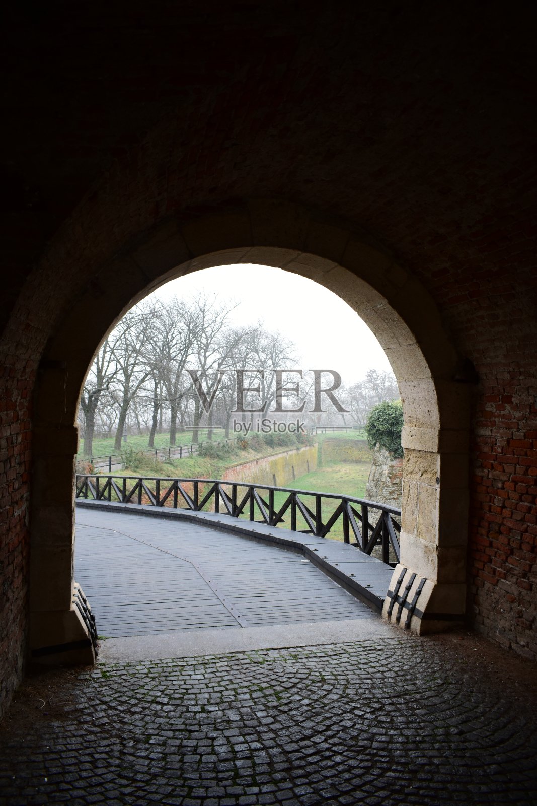 旧砖砌隧道，出口有一座木桥照片摄影图片