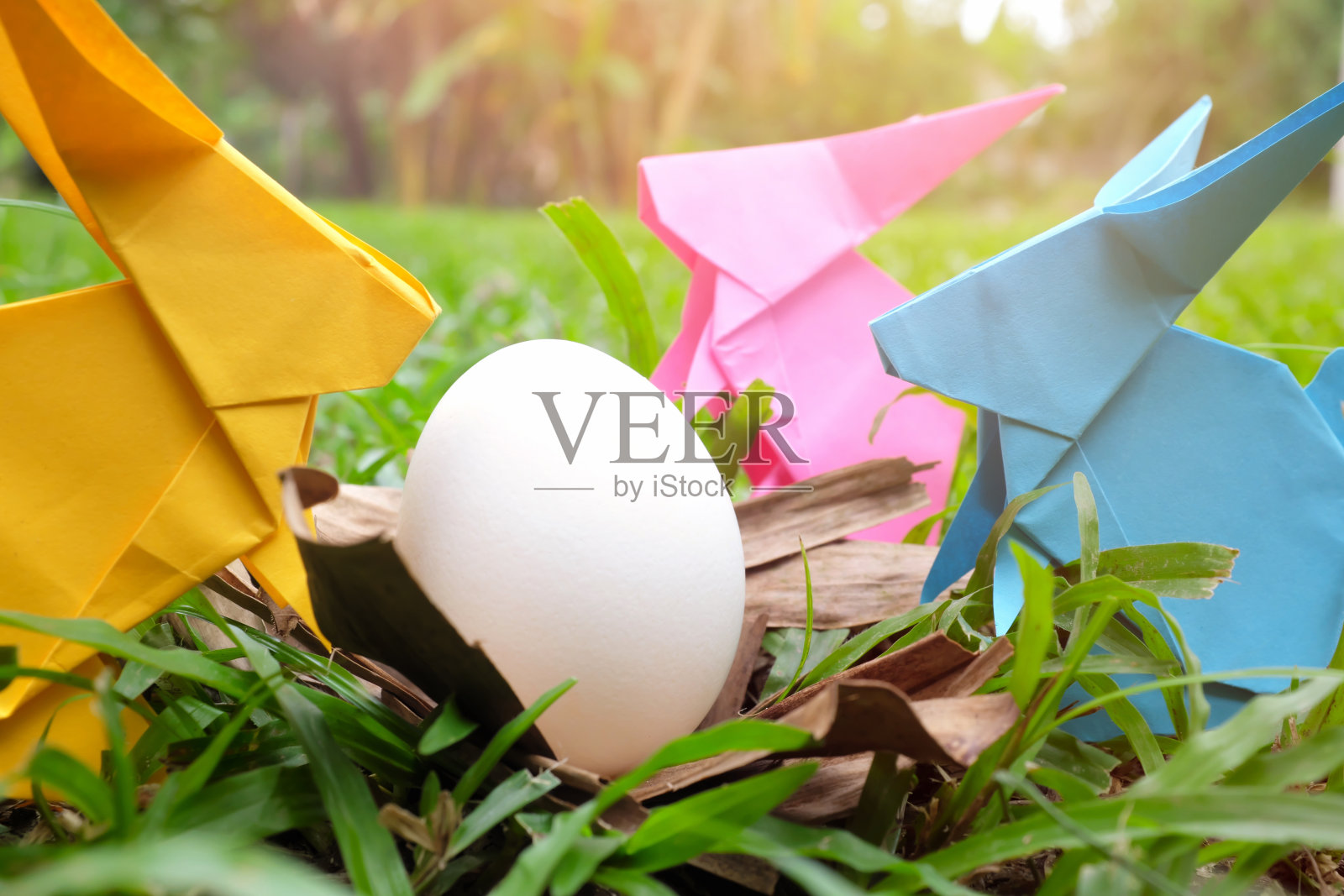 彩色和可爱的兔子兔子纸折纸与鸡蛋在花园。快乐复活节庆祝概念。照片摄影图片