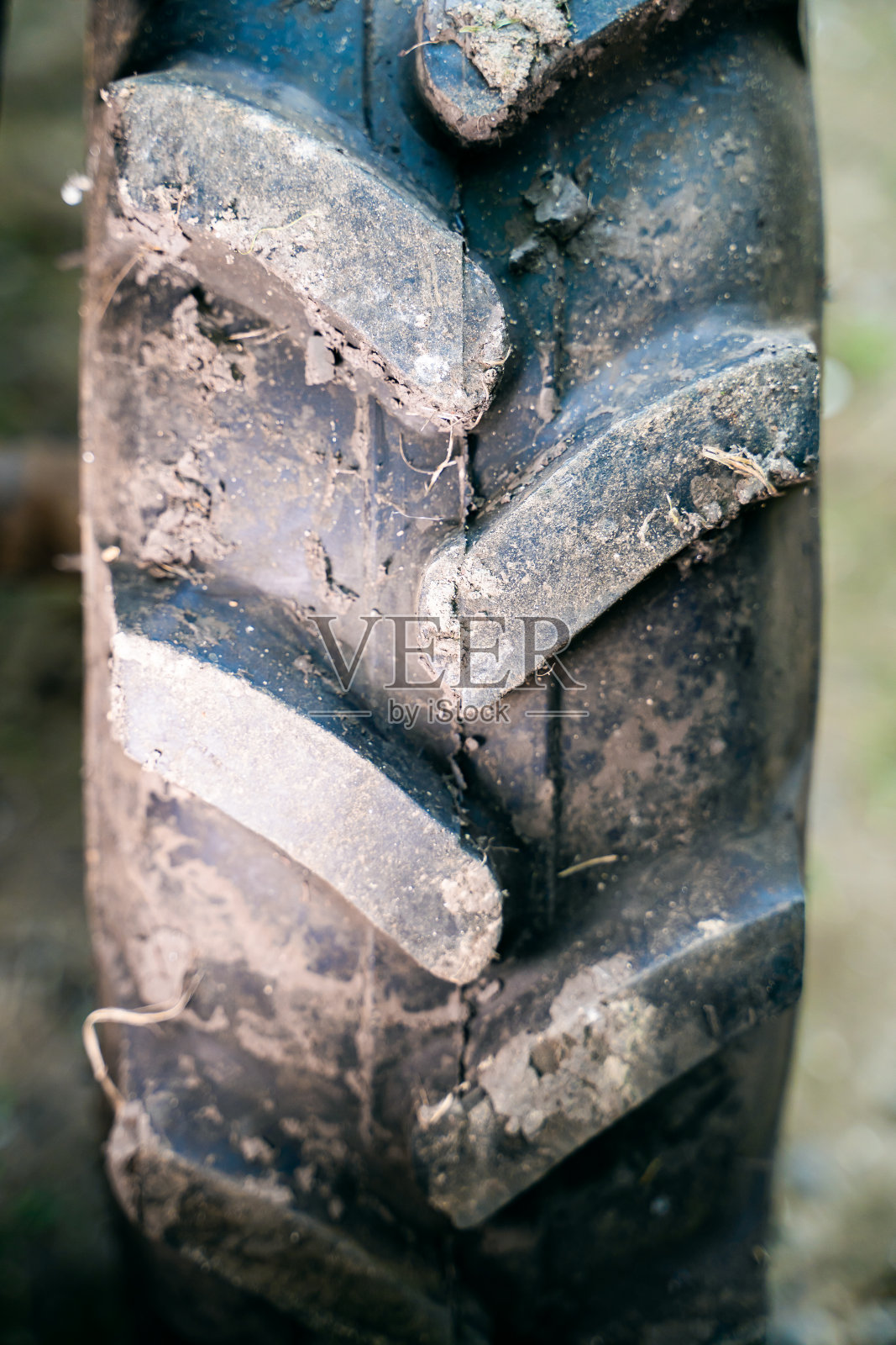 拖拉机车轮上的体积橡胶胎面特写。泥胎花纹对农机越野能力更强，垂直拍照照片摄影图片