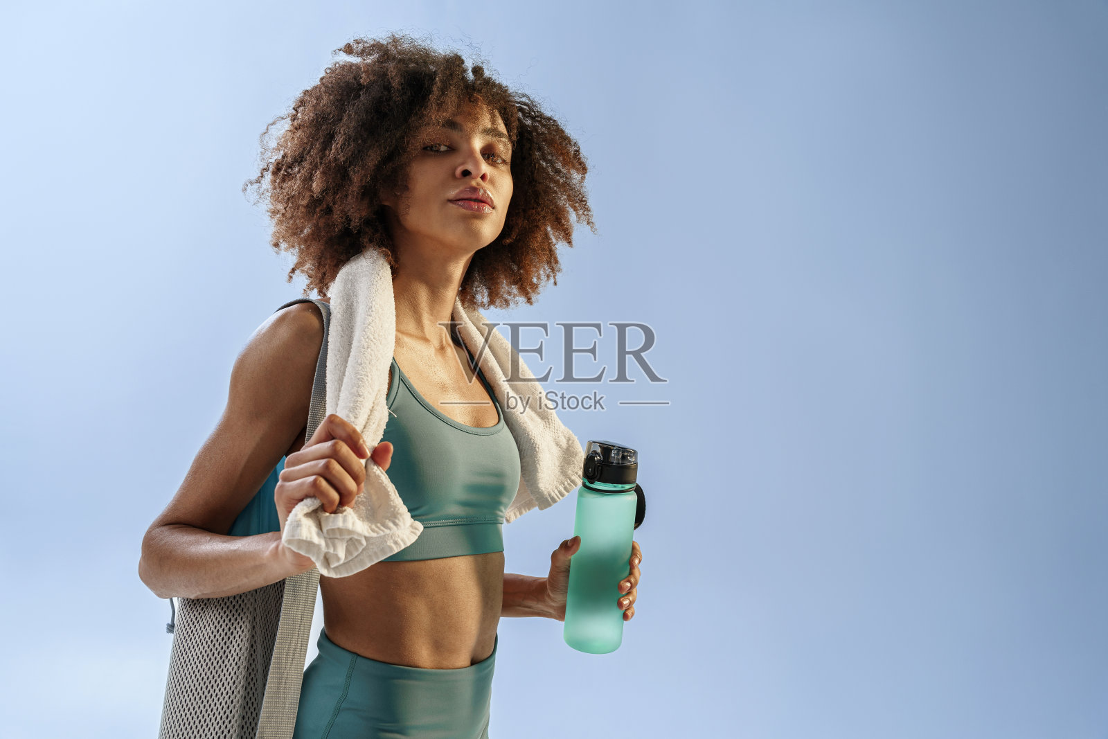微笑运动的女人与运动包和瓶水训练后的工作室背景照片摄影图片