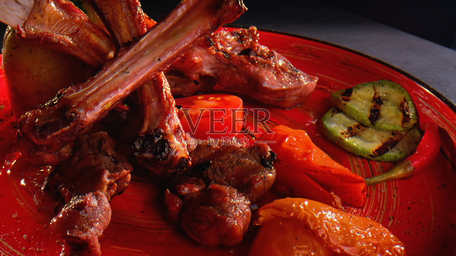 羊排配小胡瓜，红甜椒，番茄和红辣椒照片摄影图片