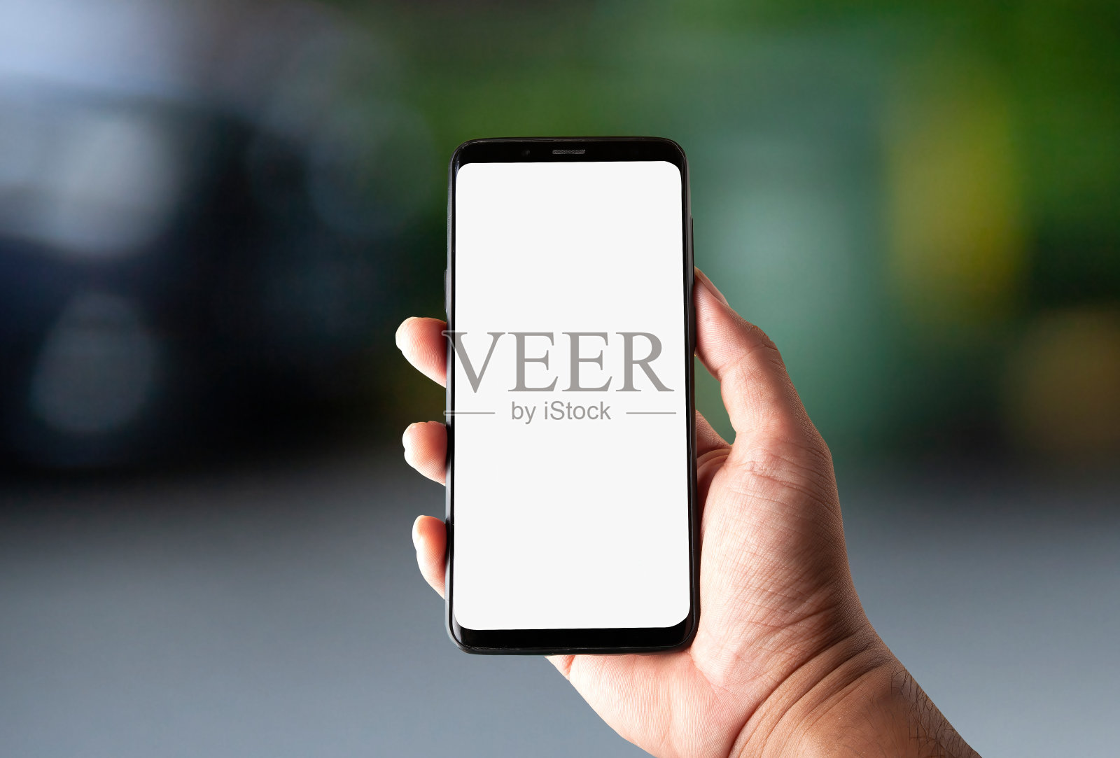 手持手机的图像与白色屏幕在自然散景背景照片摄影图片