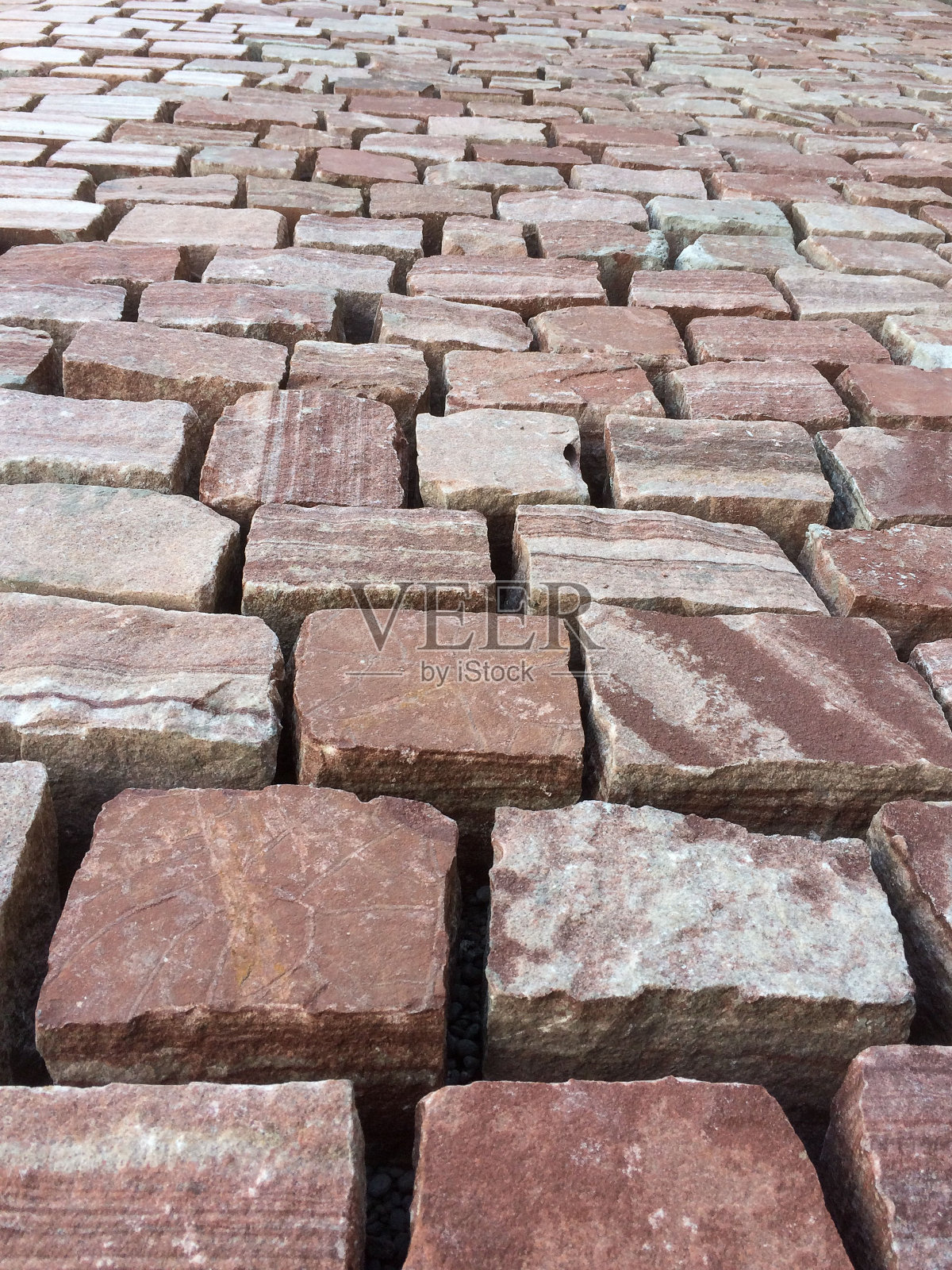 漂亮的瓷砖、石头铺路石排列在街道上，中间没有密封胶照片摄影图片