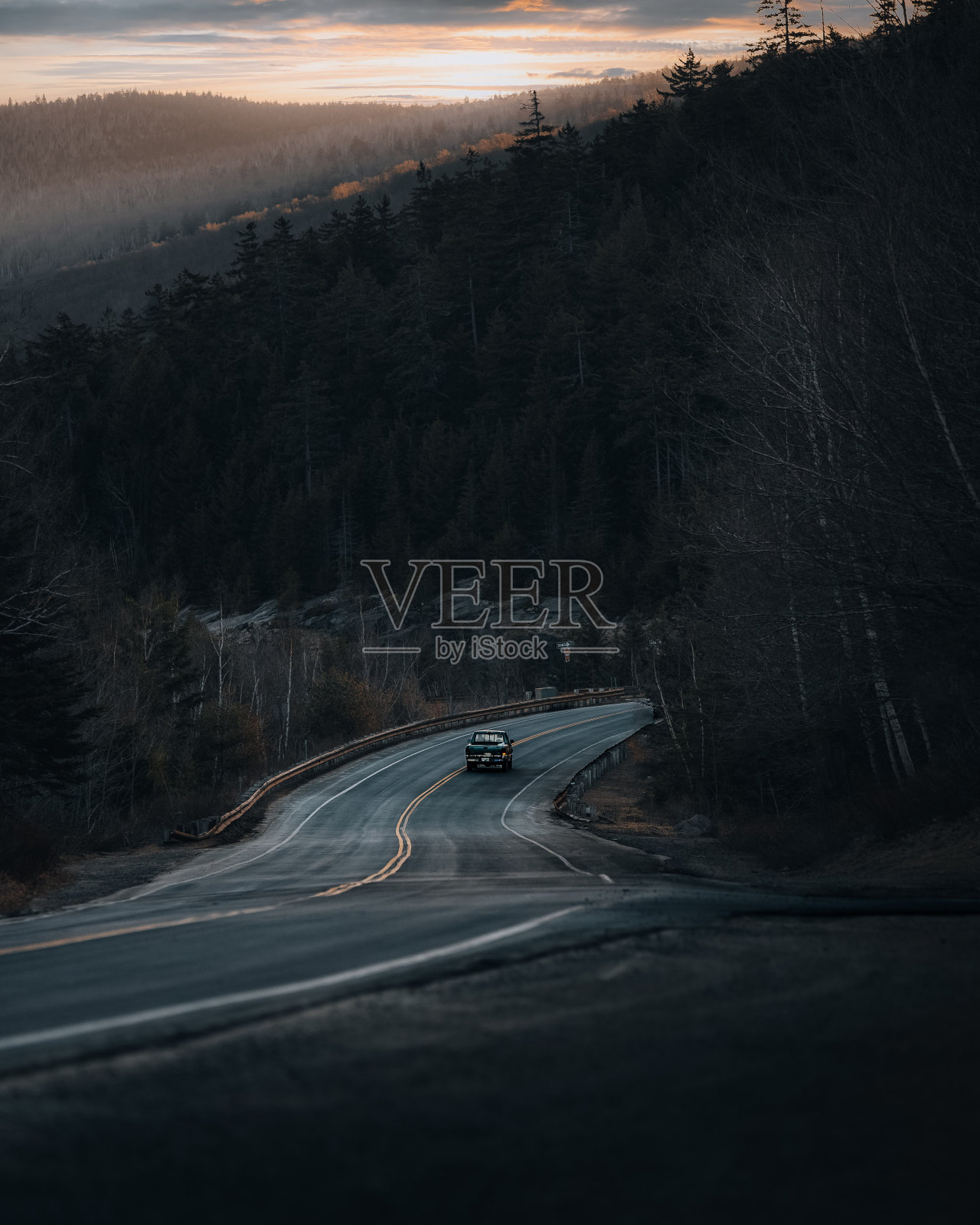 美丽的景色，一辆车在路上与森林在晚上照片摄影图片