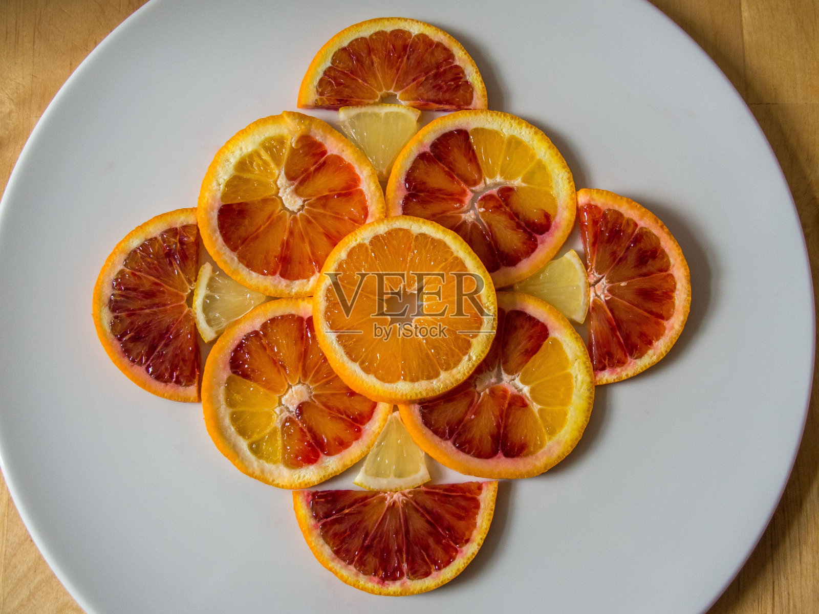 切片的橙子和葡萄柚漂亮地折叠在一个白色的盘子上照片摄影图片