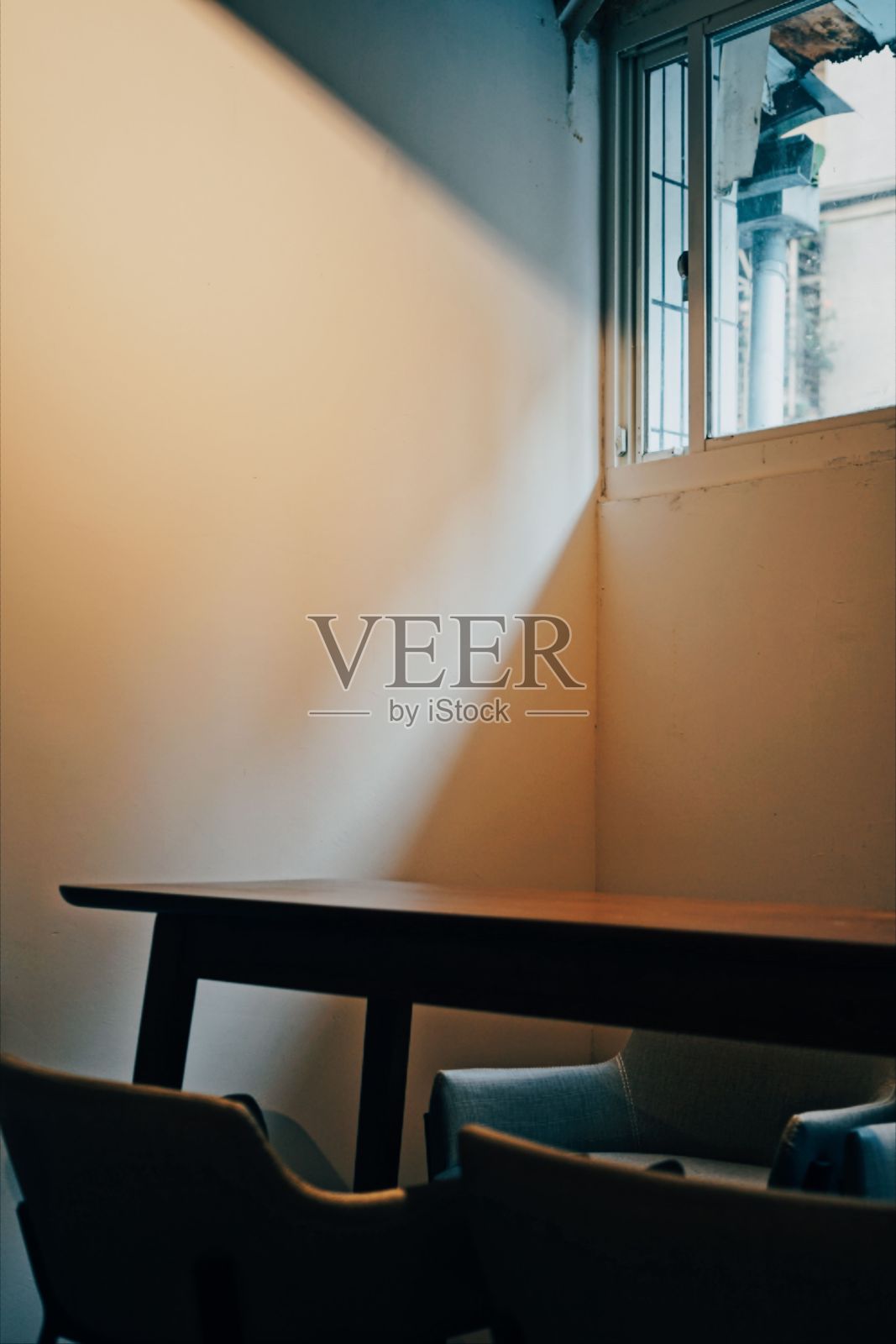 垂直拍摄了一张木桌，周围是窗户下的椅子照片摄影图片