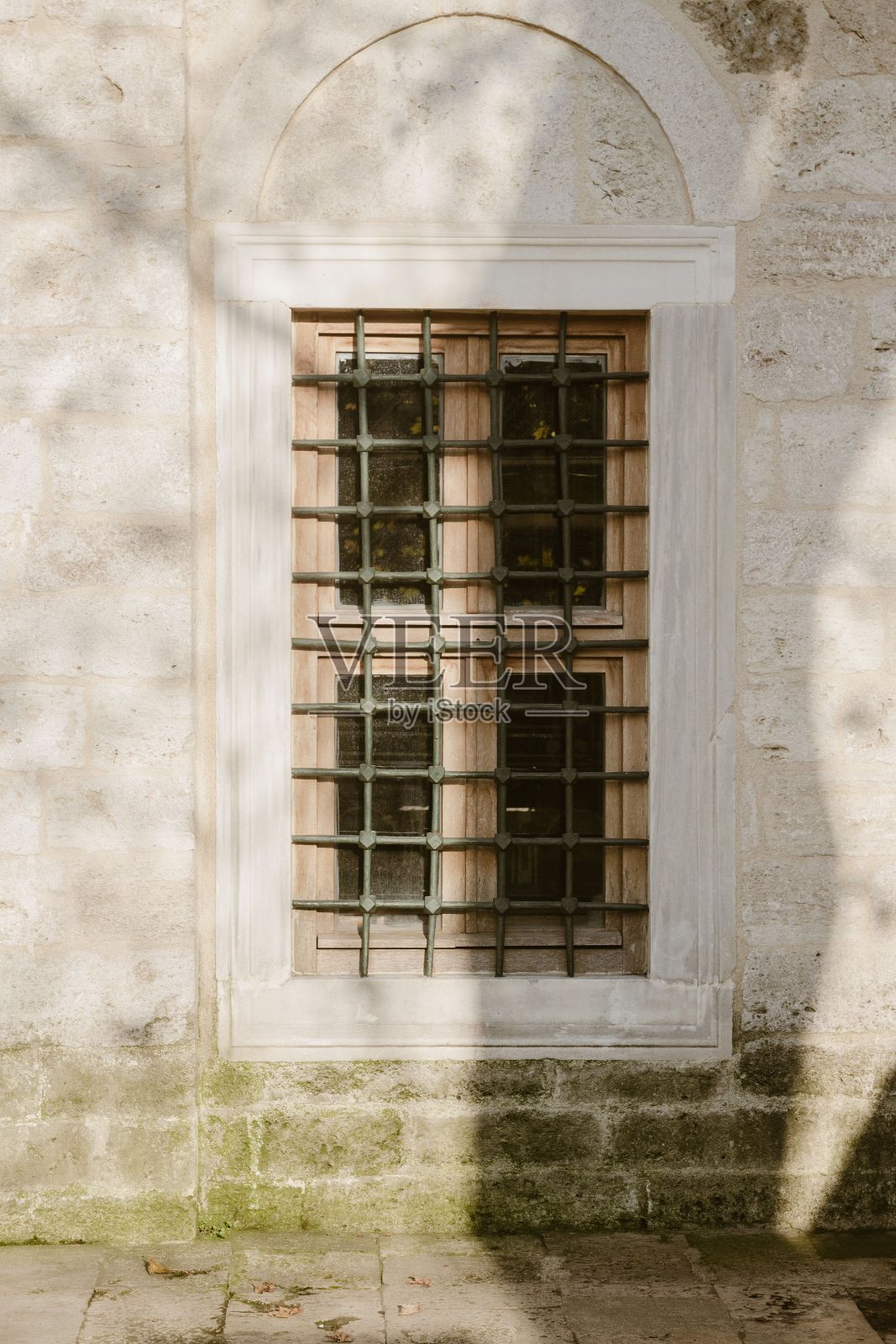 垂直拍摄锈迹斑斑的白墙上的一扇旧窗户照片摄影图片
