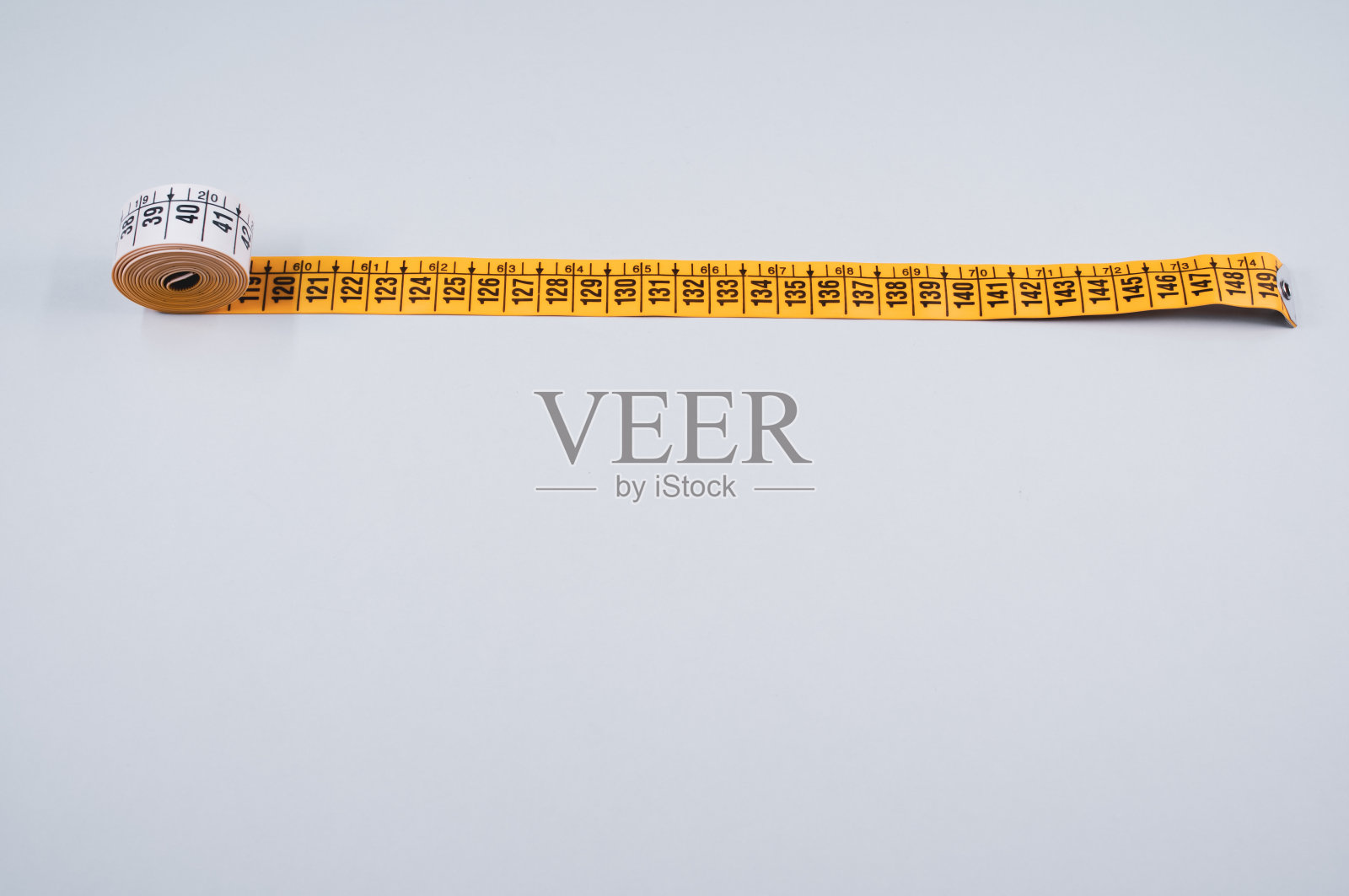 白色背景上黄色卷尺的特写镜头照片摄影图片