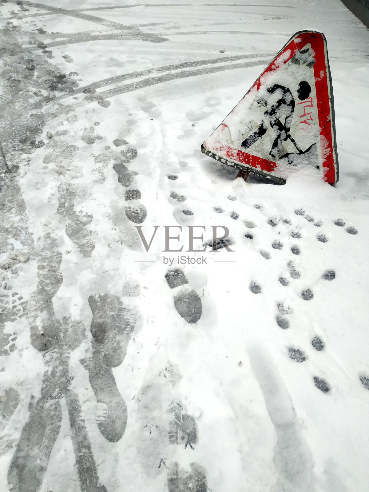 在冬天寒冷的一天，一个交通标志工作在被雪覆盖的雪地上照片摄影图片