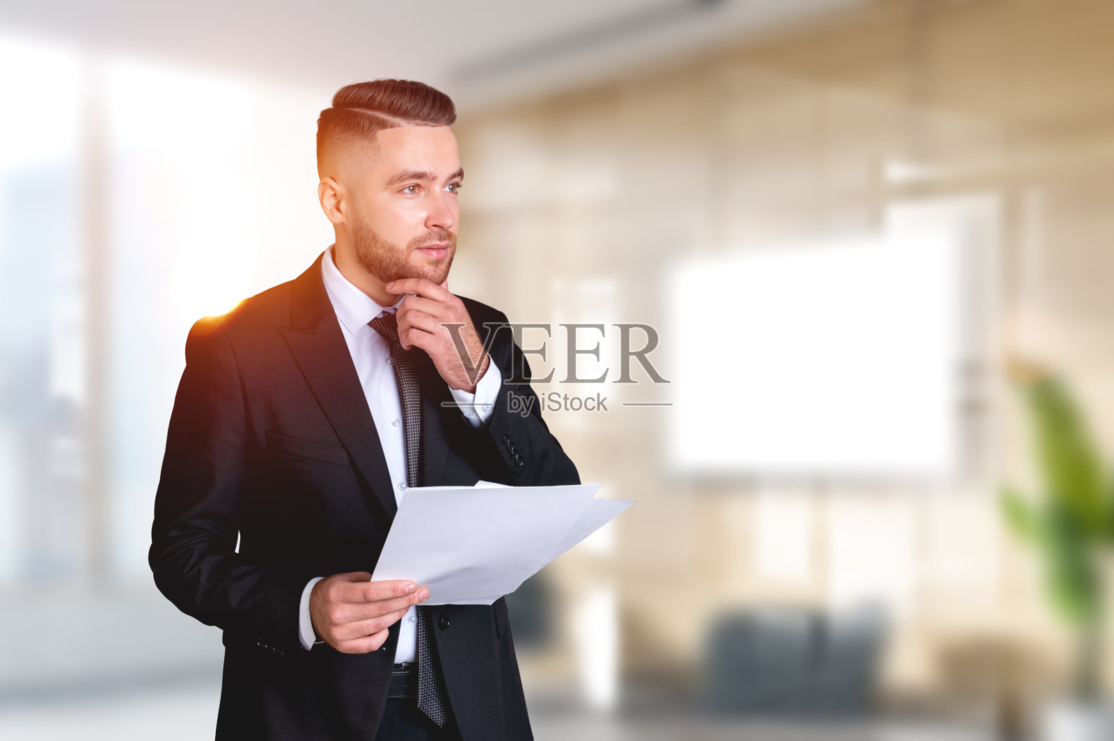 梦想英俊的商人穿着正装站着拿着合同照片摄影图片