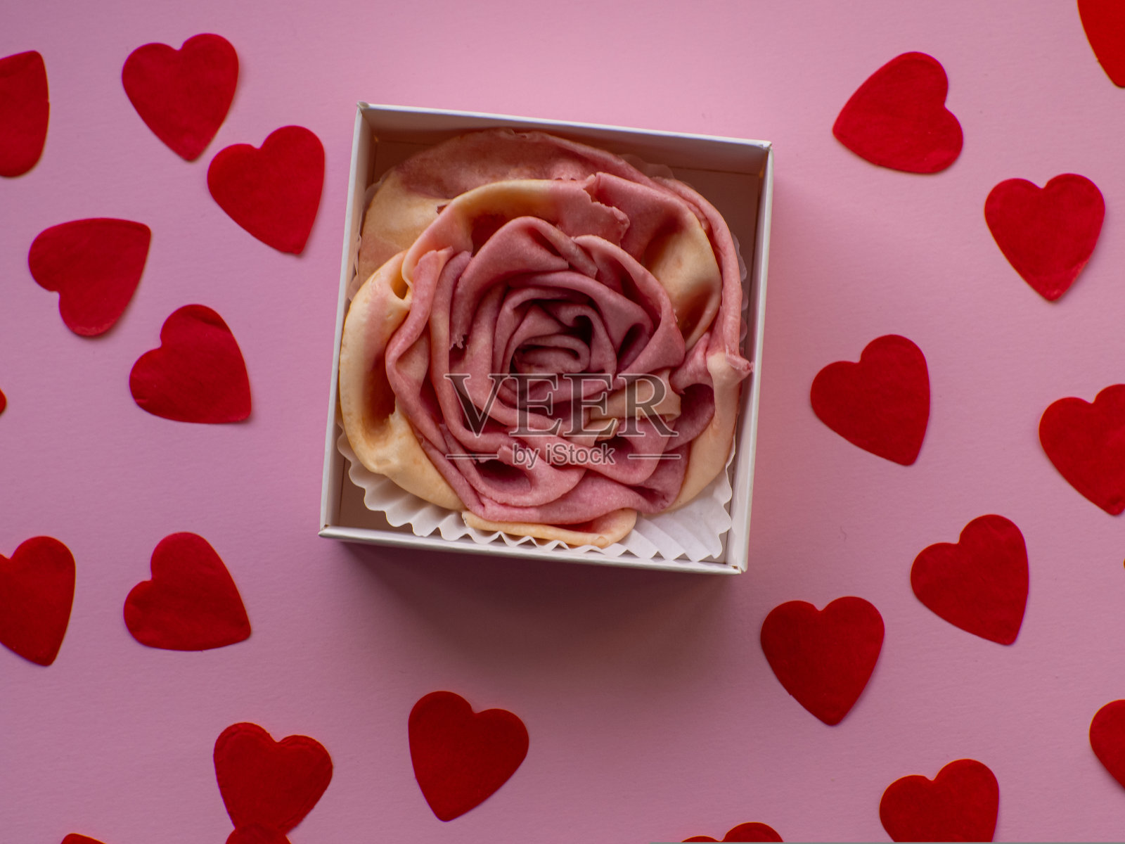 平铺着许多心形的小纸和玫瑰形的水果糖照片摄影图片