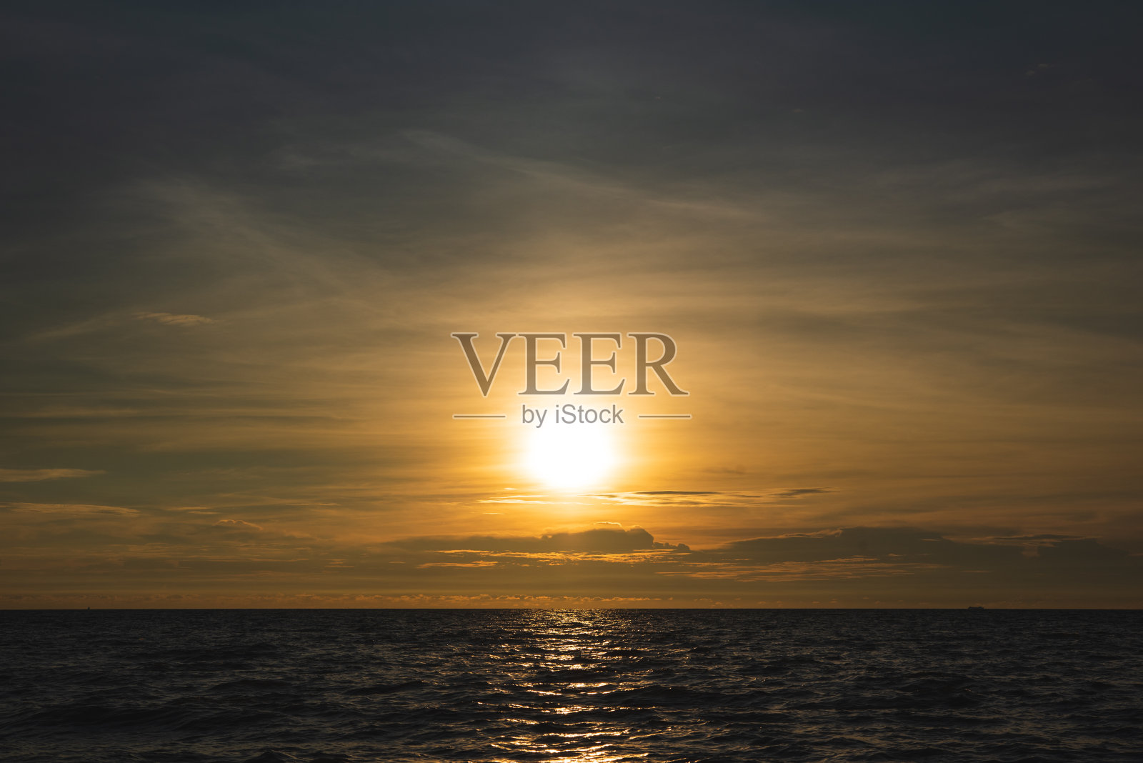 日落时海滩辉光的美丽镜头。照片摄影图片