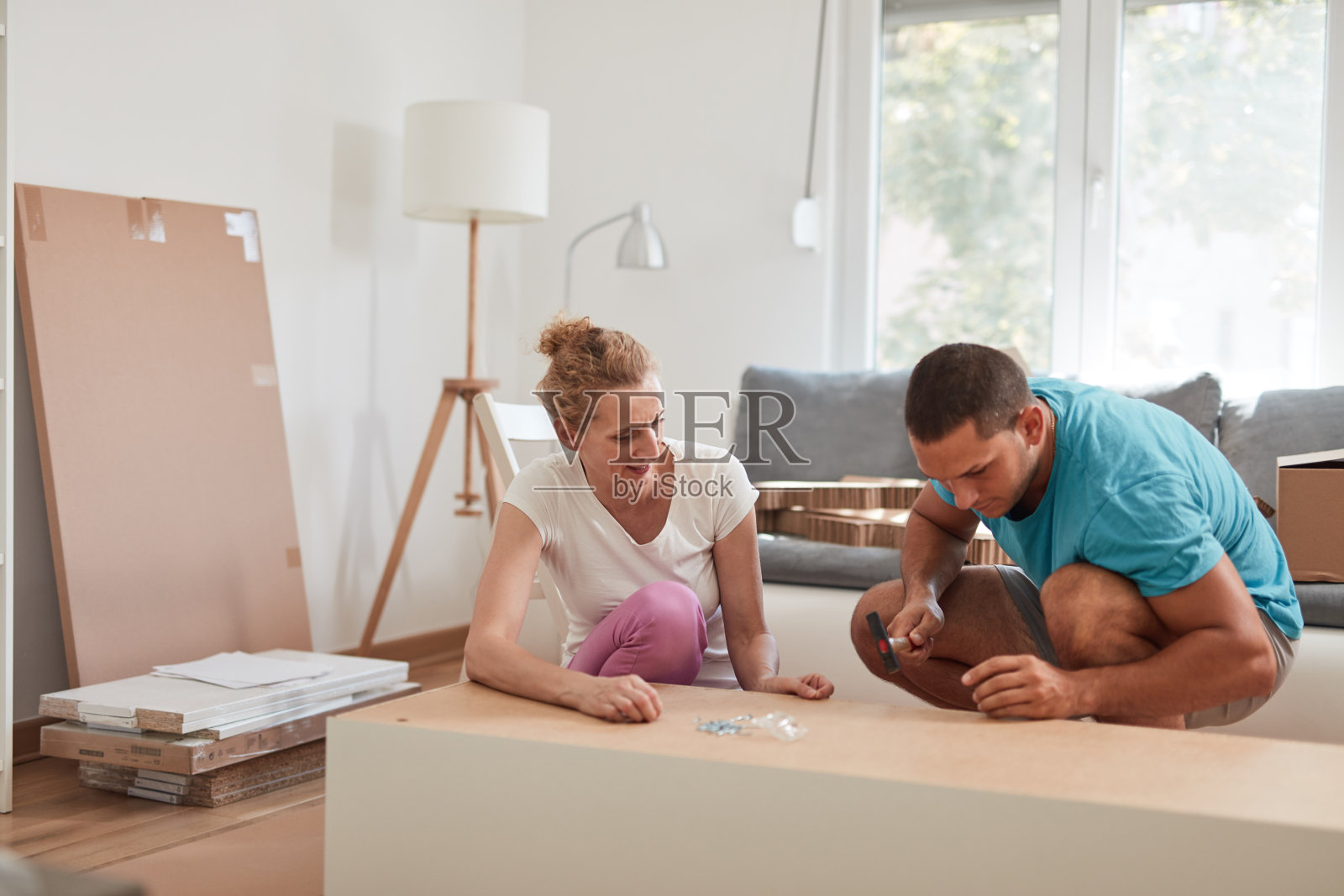 夫妻组装新家具-家居装修概念。照片摄影图片