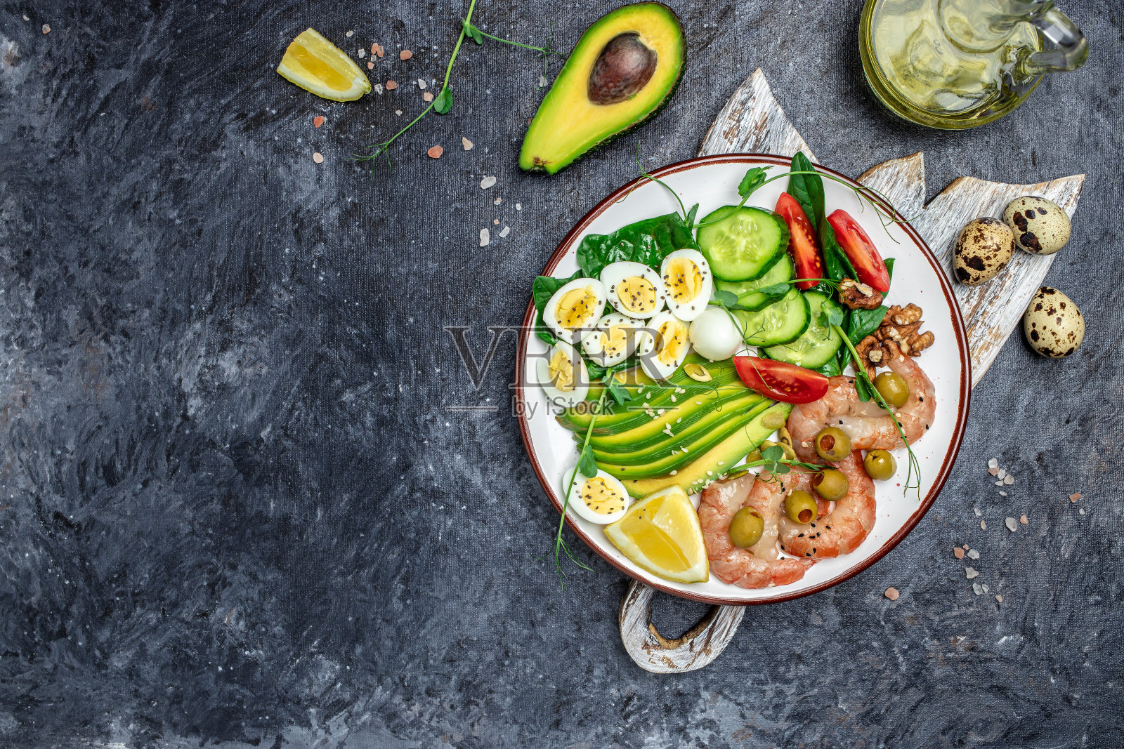 生酮早餐。生酮低碳水化合物虾，对虾，鹌鹑蛋，新鲜沙拉，西红柿，黄瓜和鳄梨在黑暗的背景。酮饮食。俯视图照片摄影图片