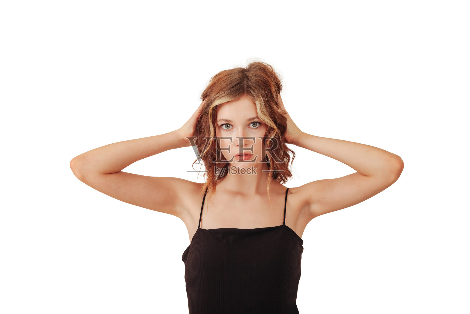 肖像的时尚少女模特在黑色连衣裙孤立的白色背景，看着相机。漂亮的少女在工作室拍摄。时尚风格概念。广告复制空间照片摄影图片