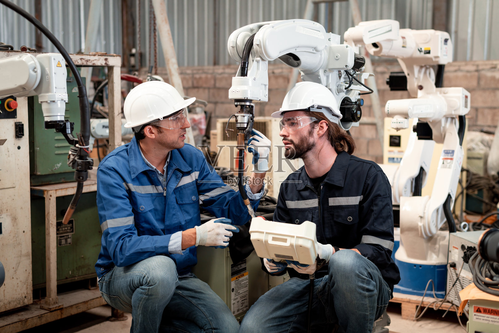 工程师工厂工业穿着安全统一的工作和检查系统的焊接机器人焊接钢电气由控制系统机器人自动化为工业制造的概念。照片摄影图片