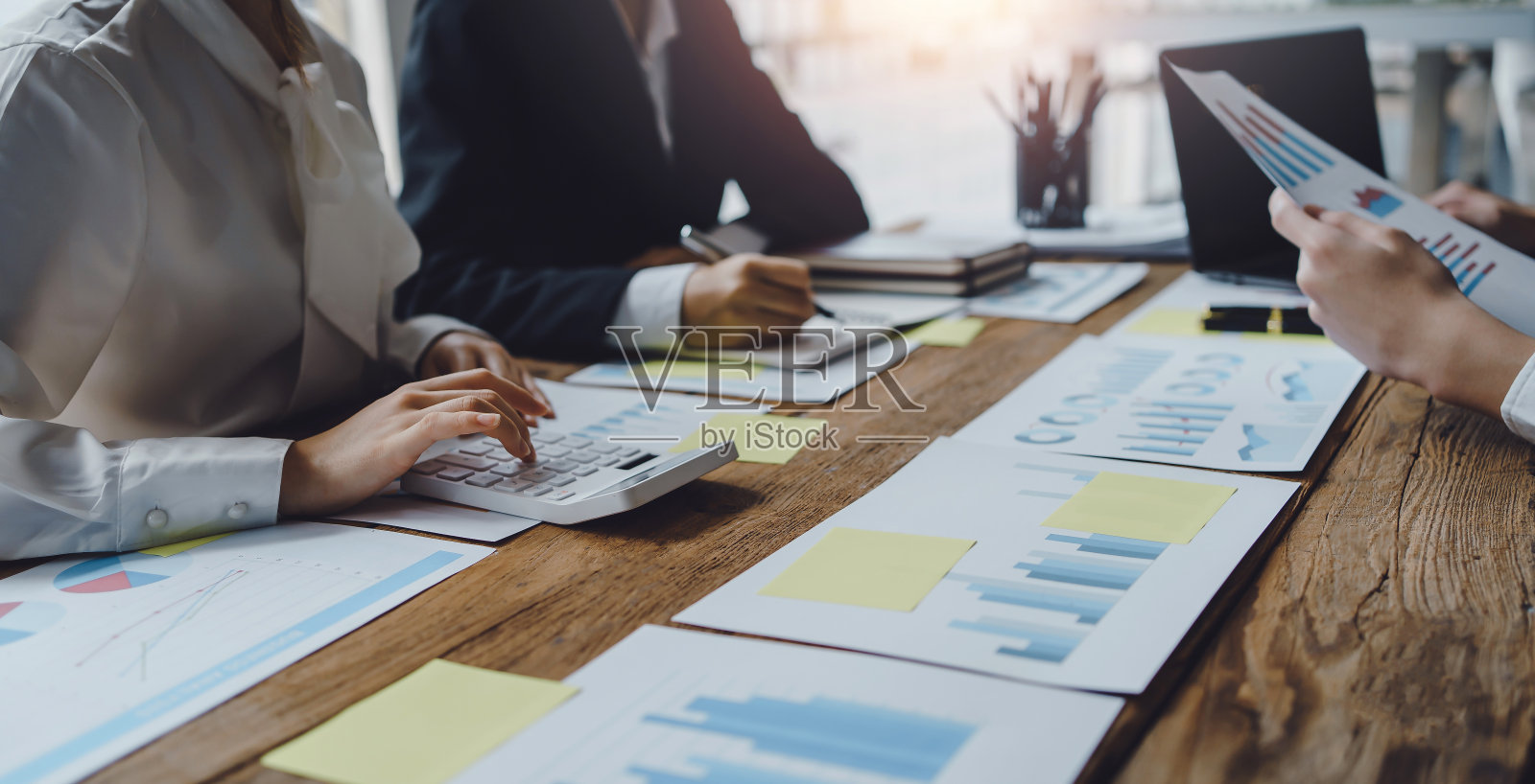 商务人士在商务会议上讨论投资项目工作和计划策略，并使用计算器。照片摄影图片