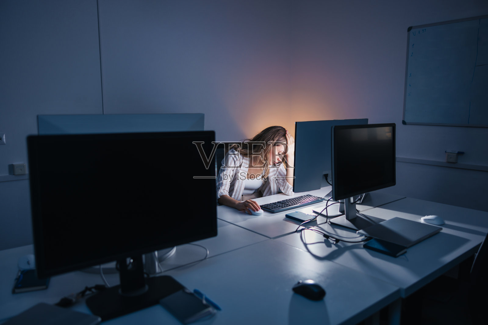 在办公室工作到很晚的女人很焦虑照片摄影图片