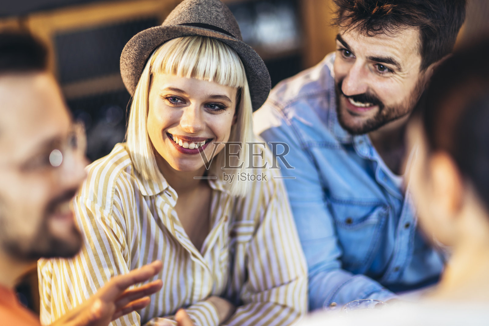 年轻人在咖啡馆里玩得很开心。朋友们坐在咖啡店里，一起喝咖啡，玩得很开心。照片摄影图片