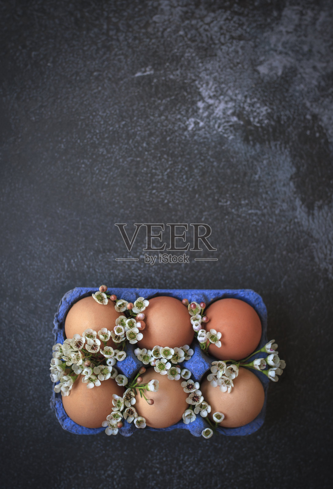 复活节彩蛋和春天盛开的花朵在蓝色纸箱黑色背景与复制空间照片摄影图片