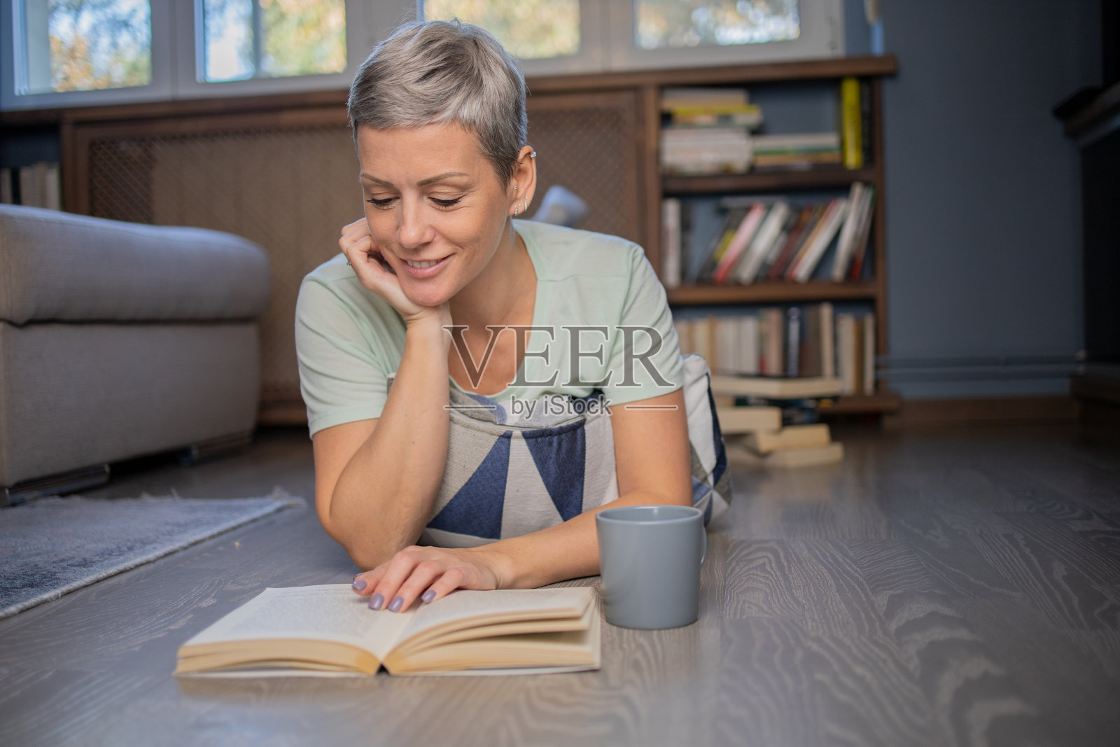 快乐的女人在家看书照片摄影图片