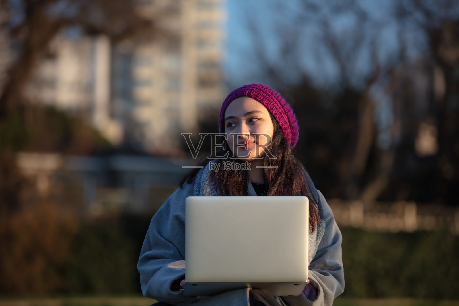 年轻的学生女孩正在外面学习。照片摄影图片