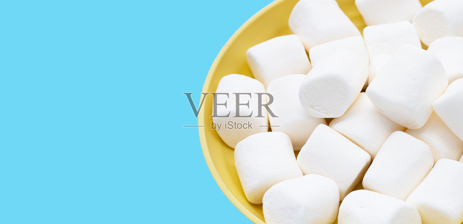 美味的白色棉花糖配上蓝色的背景。照片摄影图片