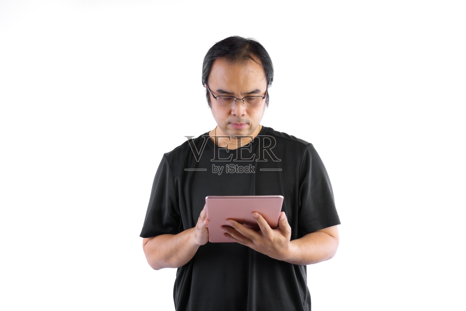 年轻的亚洲男子穿着黑色t恤和眼镜，当他看着他的平板电脑孤立在白色背景是怀疑或思考什么照片摄影图片