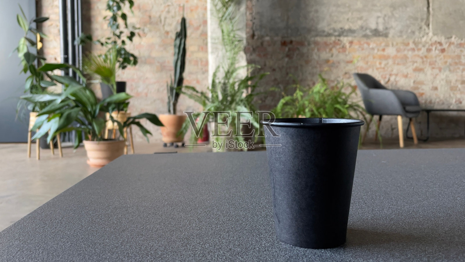 黑桶放在地上，靠在椅子和盆栽上照片摄影图片