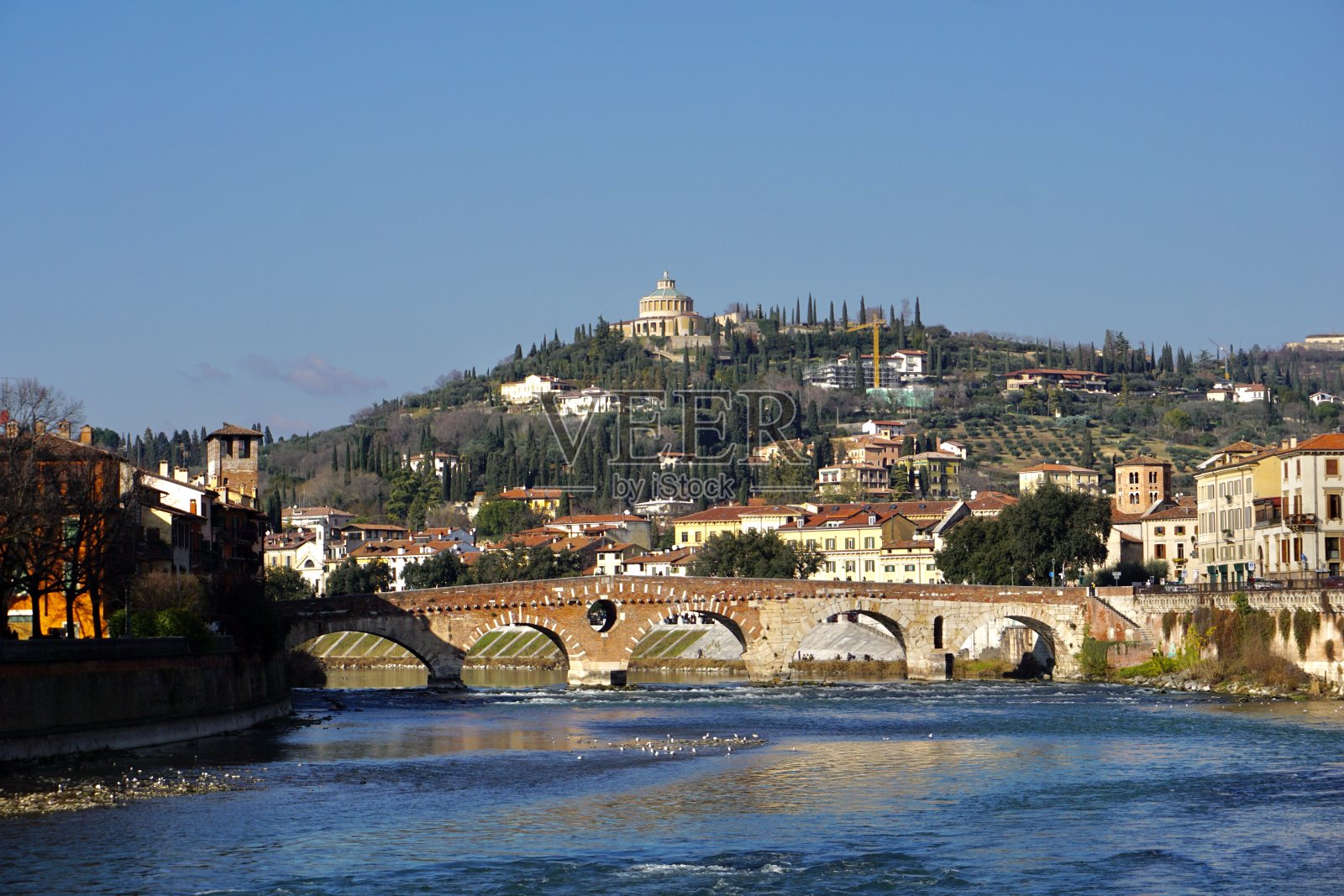 维罗纳是位于意大利威尼托的阿迪杰河畔的一座城市，拥有258,031名居民。阳光明媚的日子里，维罗纳市和阿迪杰河的全景。照片摄影图片