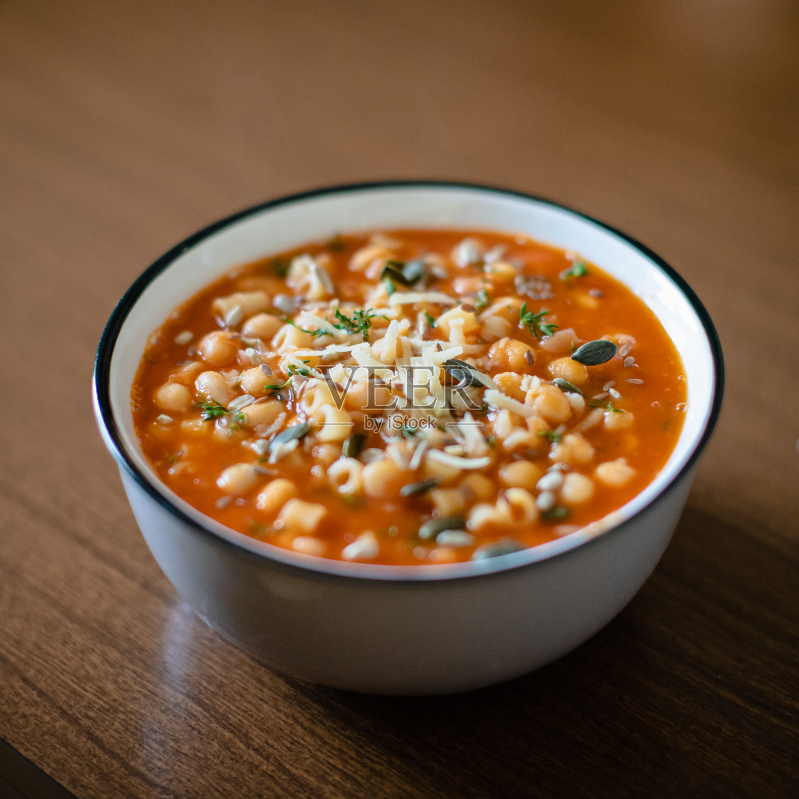 木桌上碗里鹰嘴豆汤的选择性特写照片摄影图片